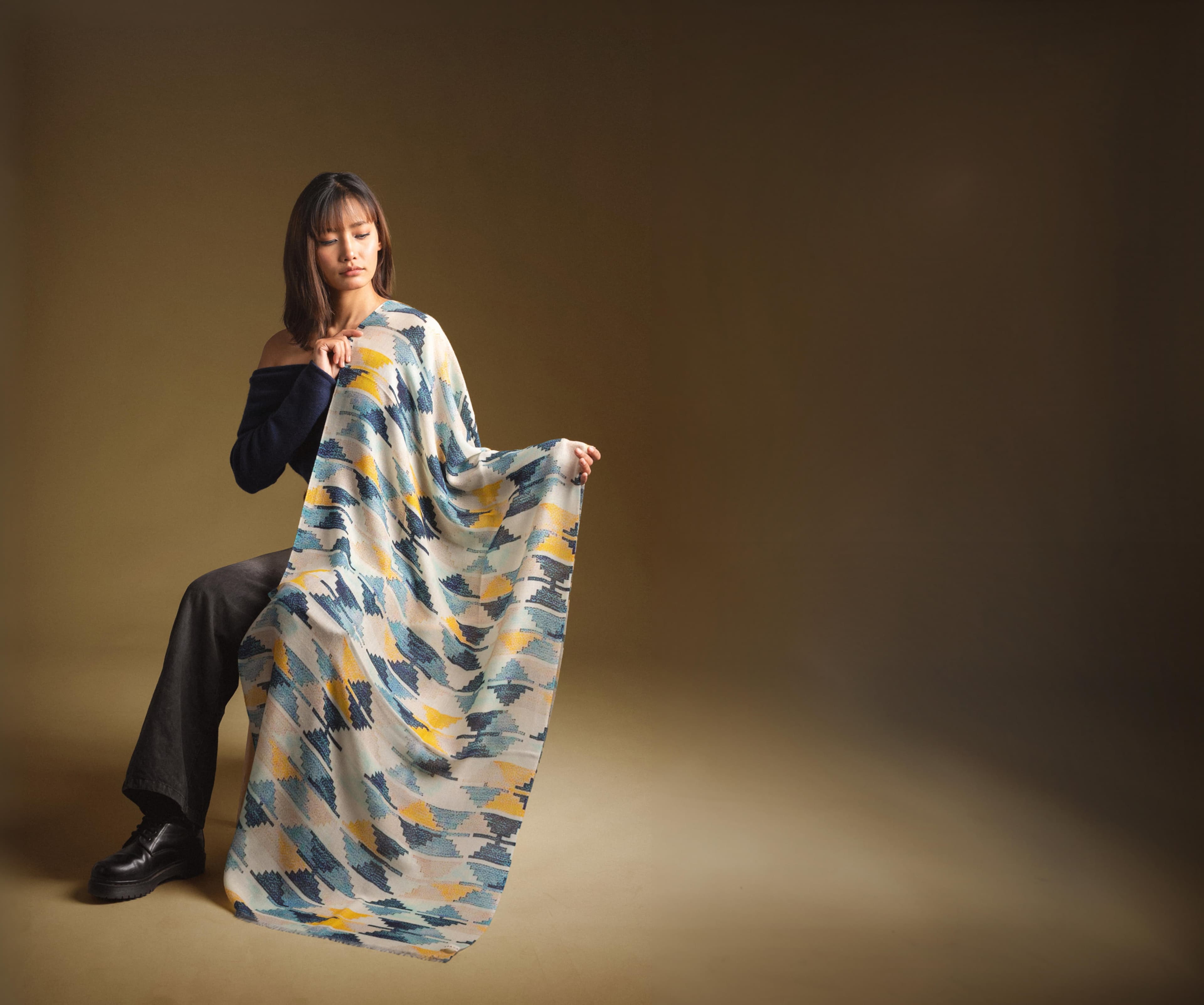 Model draping a hand-woven KPA cashmere pashmina in an ikat pattern